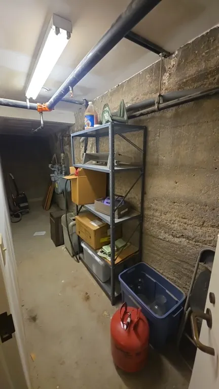 Assorted storage room contents. Includes 5-tier metal shelving unit, folding chair, plastic storage tote with glassware, Kenmore dehumidifier, floor u