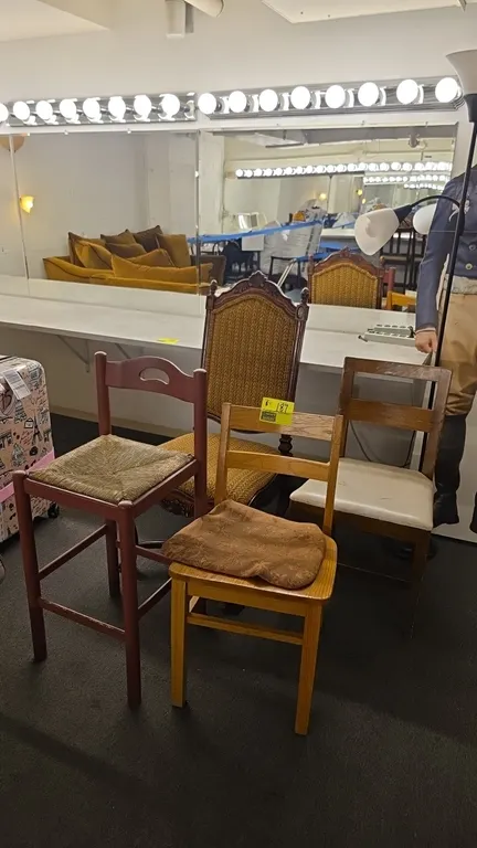 Assorted wood frame chairs. Includes high-back upholstered accent chair with carved details, counter stool with woven rush seat, and two wooden side c