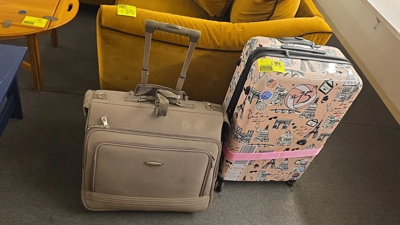 Assorted rolling suitcases. Includes (1) Karl Lagerfeld Paris hardside spinner suitcase with Paris landmark graphic print and (1) tan softside wheeled