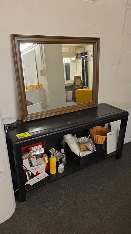 Wood console table and wood frame mirror. Features a black finish table with a lower storage shelf, measuring 53"L, paired with a 38"L molded wood fra
