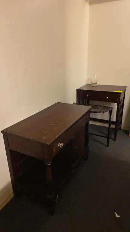 Wood tables. Includes a dark wood mission-style table featuring slatted sides and a pull-out tray, and a vintage demi-lune accent table with turned le