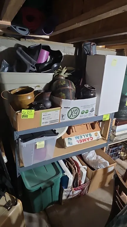 Assorted household decor and storage contents. Includes assorted decorative vases, planters, plastic storage totes, seat cushions, wooden wall rack, v