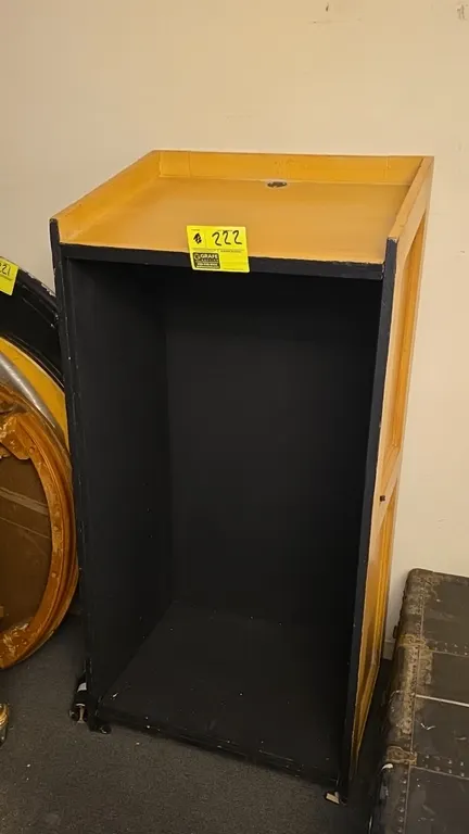 Wood podium. Features an angled top surface with cord pass-through grommet, natural wood finish exterior, and open rear storage compartment. Dimension