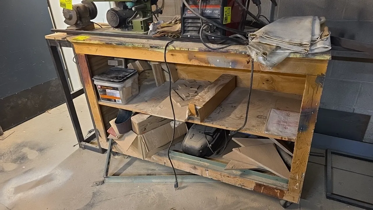 Workbench and stand lot. Includes 60" wood 3-tier portable table mounted on casters and 20" table with wood top and metal base frame. Contents, tools,