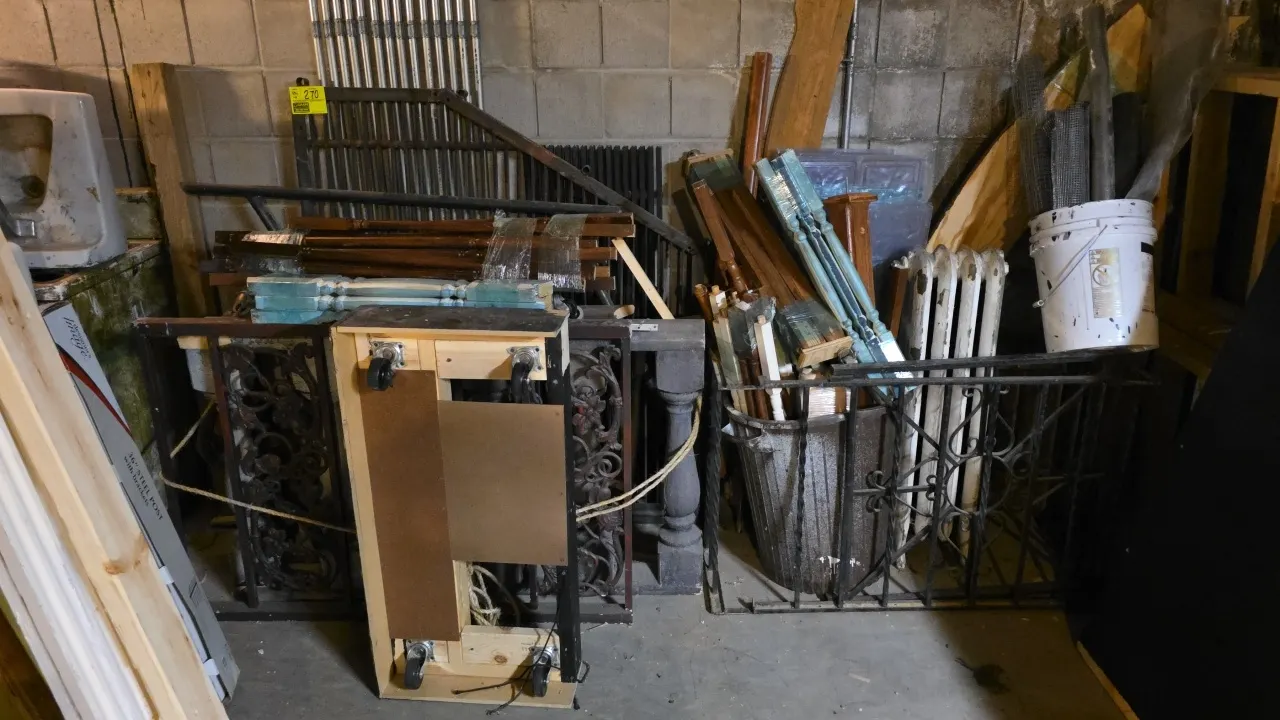 Assorted wood and metal building materials and architectural salvage. Includes decorative metal railings, turned wooden balusters, metal conduit pipes