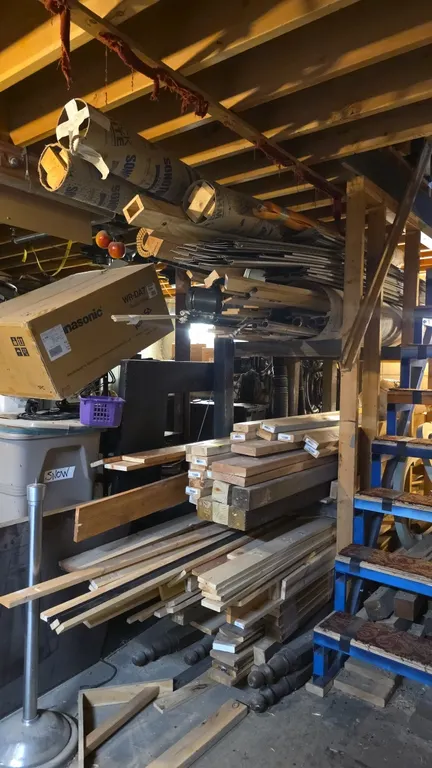 Assorted lot of construction materials and lumber. Includes dimensional lumber boards, framing timber, turned wood posts and spindles, metal trim stri