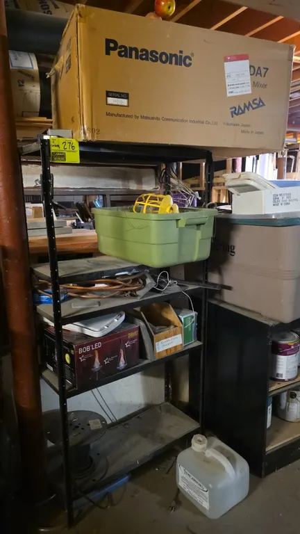 Metal warehouse shelf with compressed wood shelves and contents. Includes assorted contents across shelves such as wire spool, copper tubing, storage