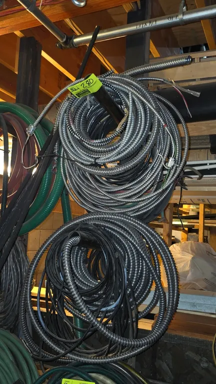 Assorted flexible metal electrical conduit. Includes various coils of flexible metallic conduit and armored cable. Note: Extension cords, garden hoses