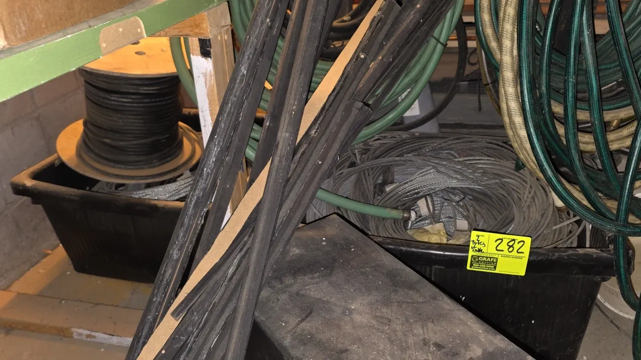Poly storage bins with assorted metal cable. Includes coiled wire rope/aircraft cable and a spool of electrical cable housed in heavy-duty black plast