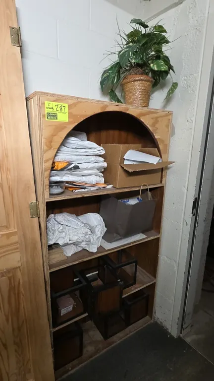 Wood bookshelf with contents. Features an arched top opening and 4 storage shelves. Includes assorted shelf contents as pictured. 33"W x 63"H.