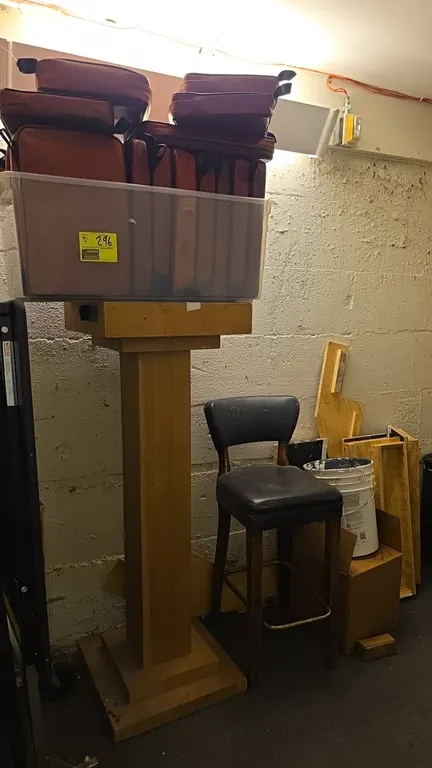 Assorted lot of contents. Includes upholstered seat cushions in a plastic storage tote, (1) cushioned bar stool with wood frame, a 20" x 55" wood mant