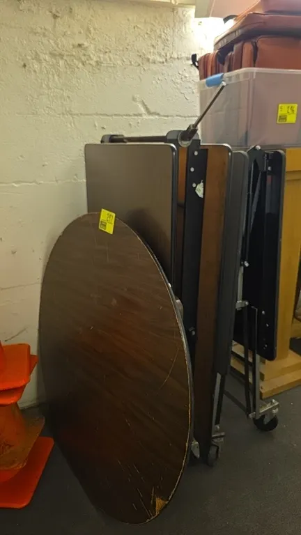 Laminate wood folding tables. Includes mobile lunchroom folding tables mounted on casters and a circular folding table. Features woodgrain laminate to