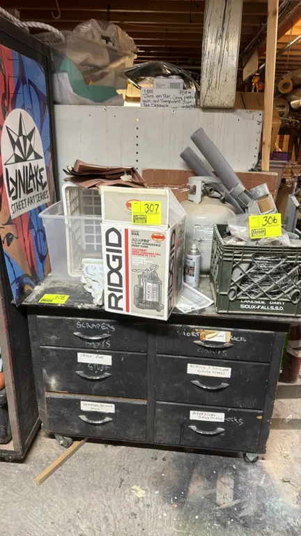 Wood work cabinet. Features a 6-drawer configuration with metal pulls. 4'L. Mounted on casters. Contents and items on top not included.
