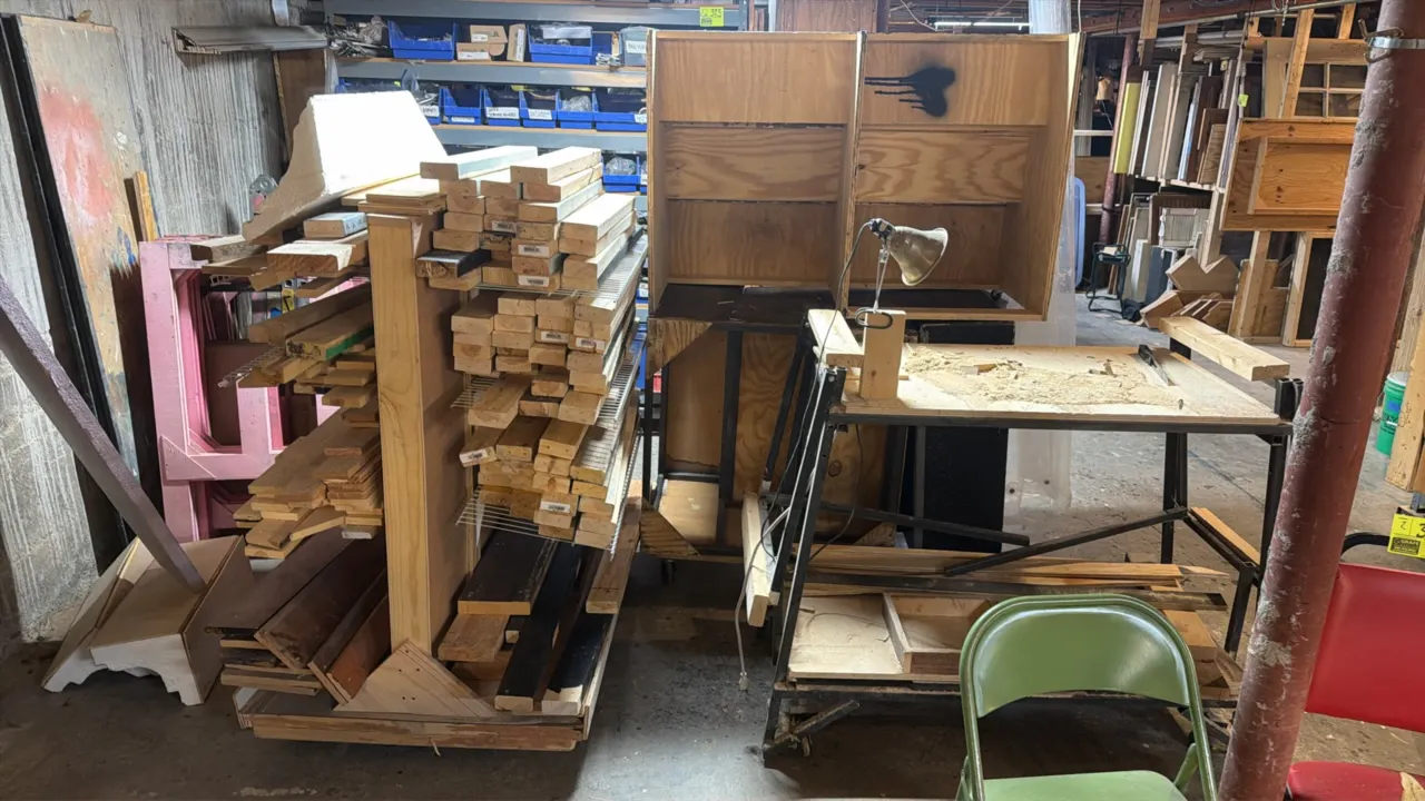 Assorted custom portable wooden carts and work table. Includes (1) double-sided rolling lumber storage rack, (1) metal-frame work table with lower she