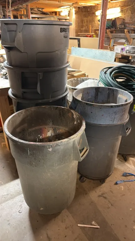 Rubbermaid Brute poly trash cans. Features molded side handles, round commercial plastic construction, and rolling caster dollies on select units. Con