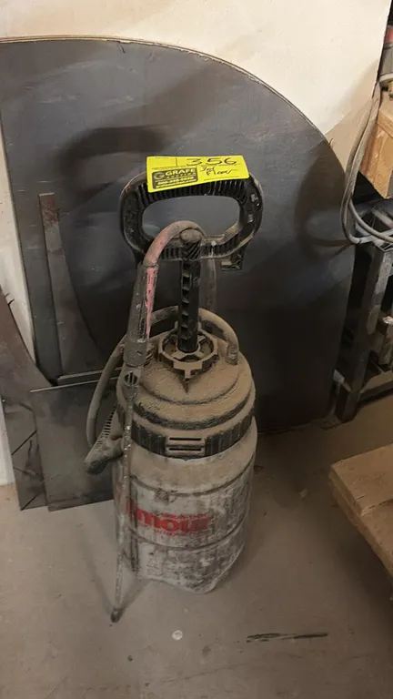Pump sprayer. Features manual pressure pump mechanism with integrated carry handle, spray wand, and flexible hose.