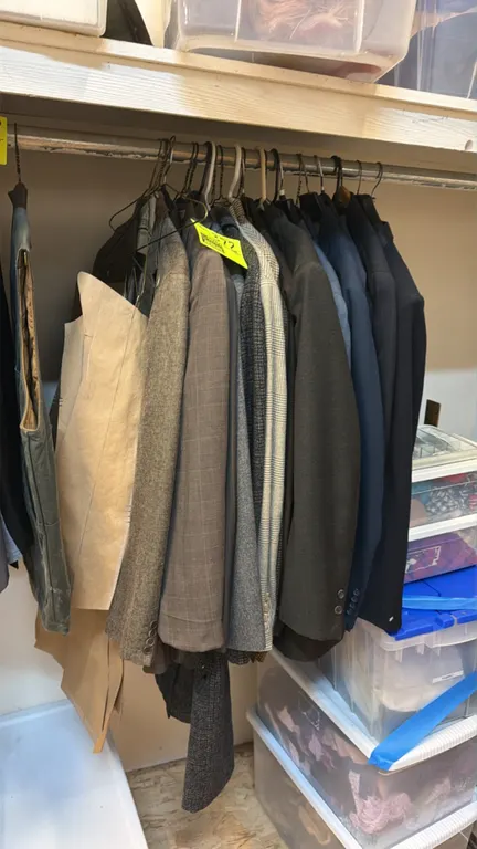 Assorted collection of jackets and coats. Includes suit blazers, patterned sport coats, and a full-length overcoat in various styles, fabrics, and pat