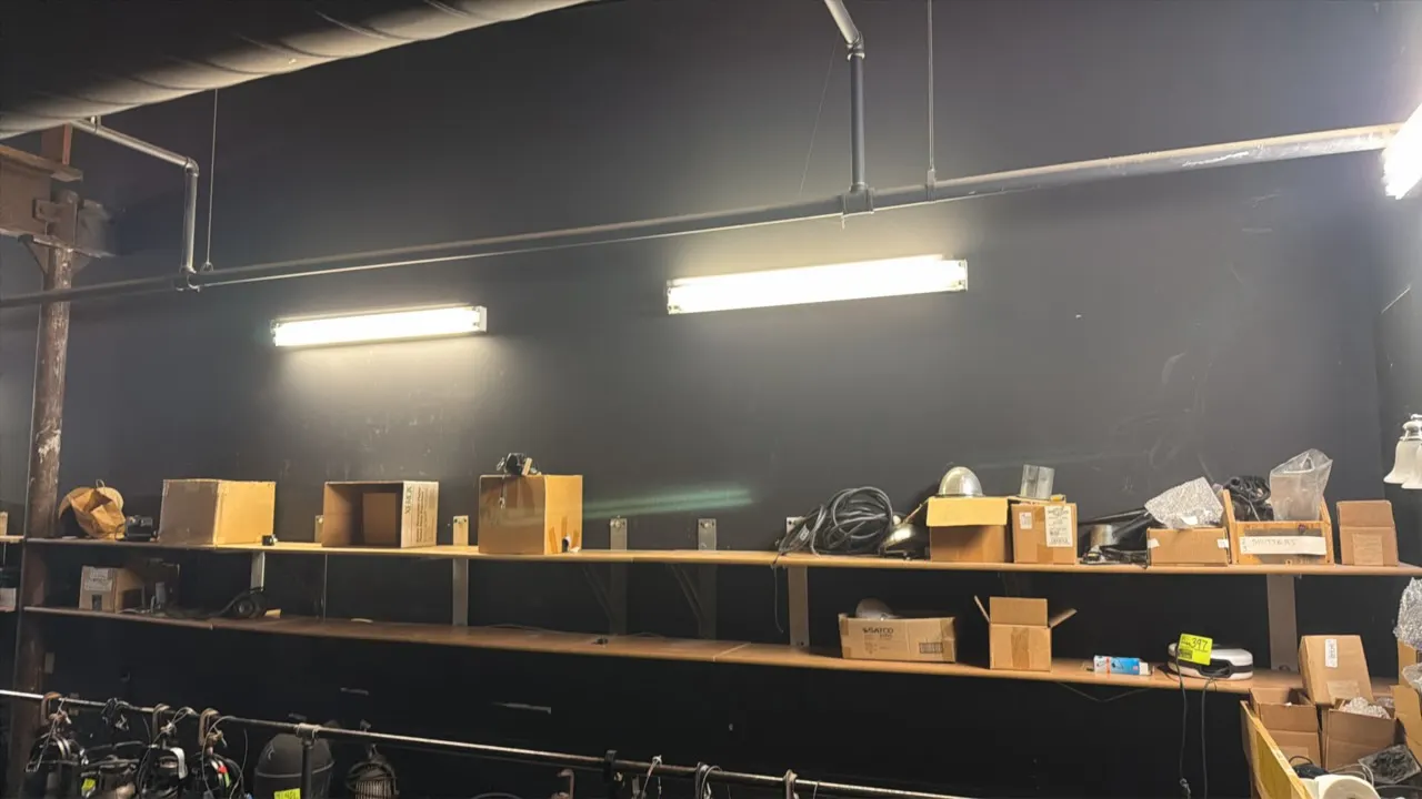 Assorted stage lighting parts and accessories. Includes wall-mounted mini stage lights, reflectors, retractable cord reel, electrical cords with stage