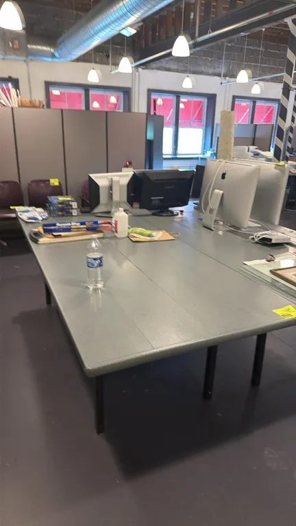 Composite folding table. Features a gray top with bullnose edges and black folding metal legs. 8'L x 3'W x 2.5'H. Contents not included.