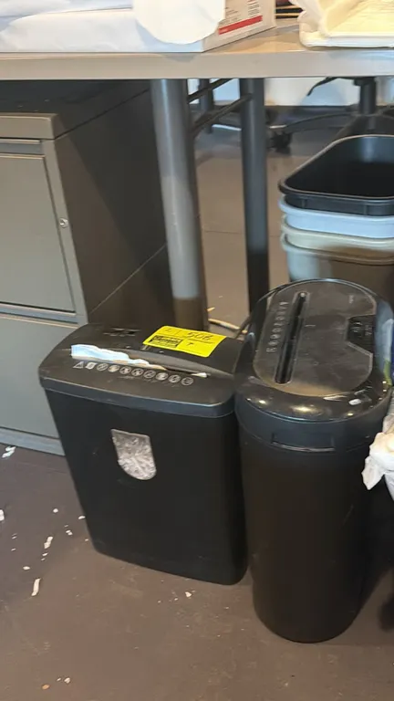 Assorted electric paper shredders. Includes (2) freestanding units with integrated waste bins. Office furniture and background items not included.