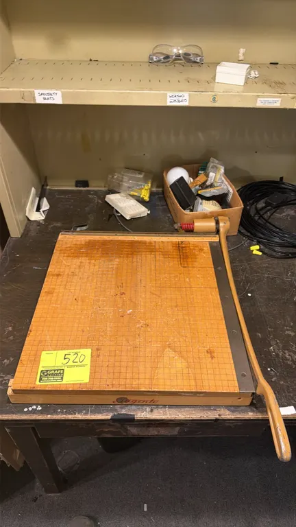 Ingento wood paper cutter. Features a grid-lined wooden cutting board, top alignment ruler, and spring-action guillotine cutting arm. Background items