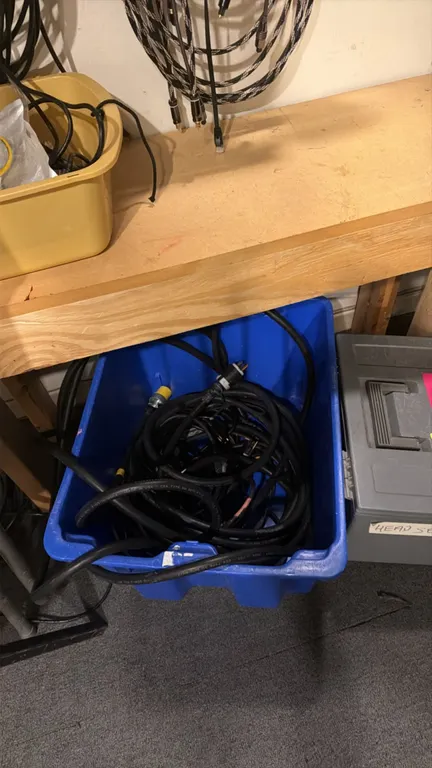 Assorted cables, wires, and storage totes. Includes Cat 5 networking cables, HDMI cords, audio cables, and heavy-duty power cables. Also includes a bl