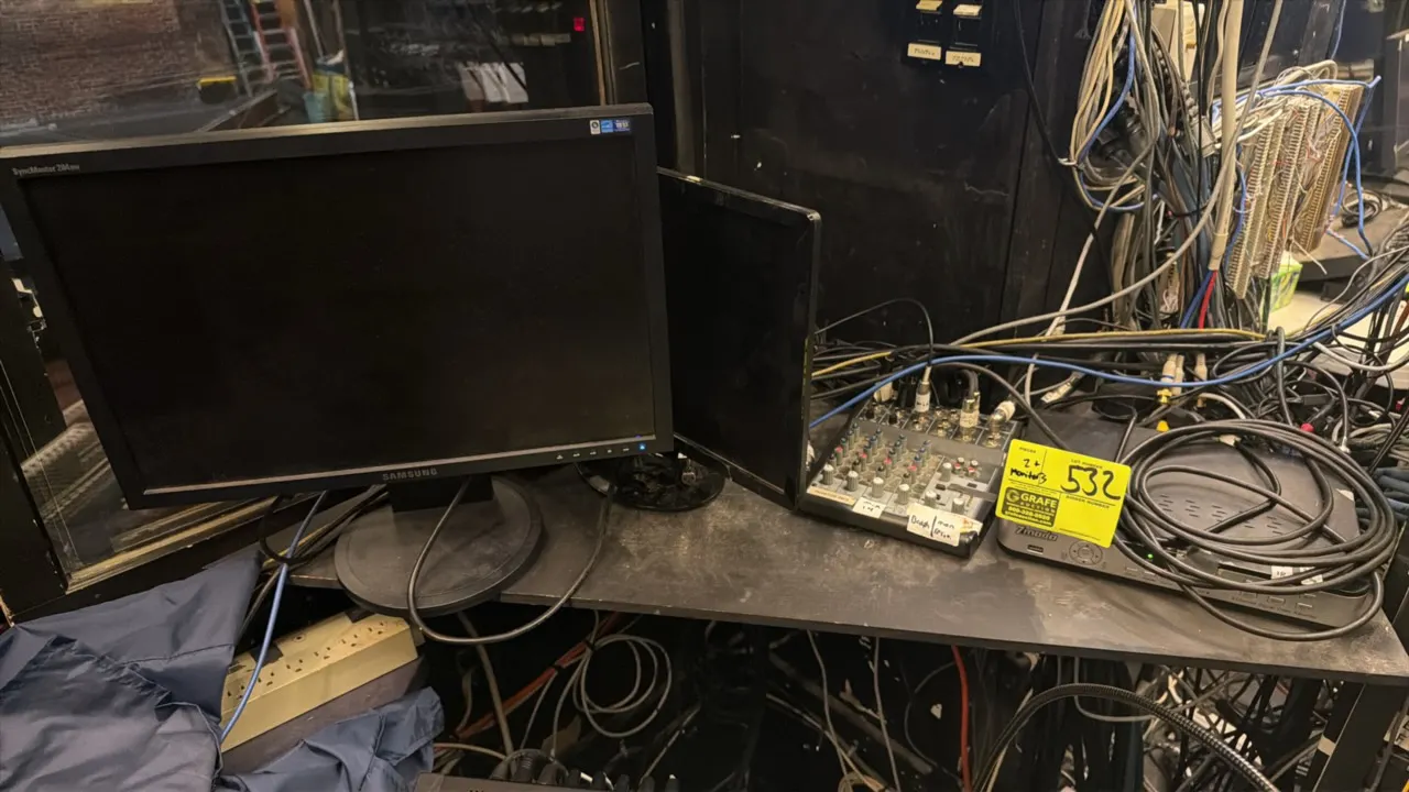Assorted computer monitors. Includes Samsung SyncMaster LCD monitor and companion desktop display. Mounted on circular desktop stands. Audio equipment