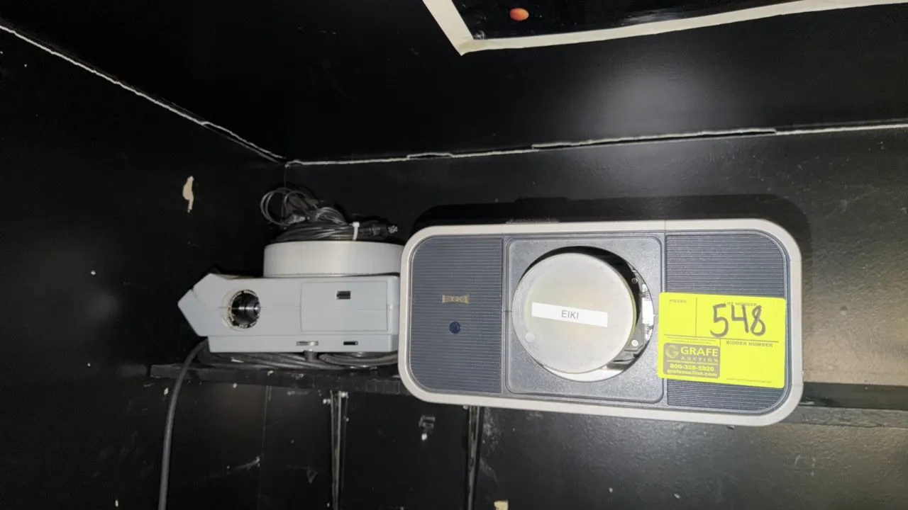Assorted commercial projectors including (1) Eiki multimedia projector and (1) Kodak carousel slide projector. Features power cords and protective len