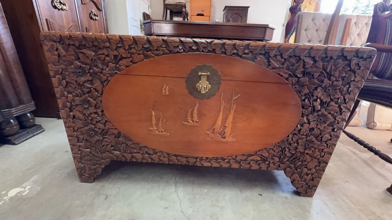 Chinese Rectangular hand-carved wooden chest featuring detailed floral carvings across the exterior