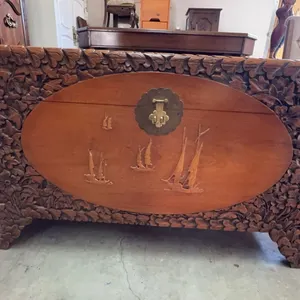 Chinese Rectangular hand-carved wooden chest featuring detailed floral carvings across the exterior 