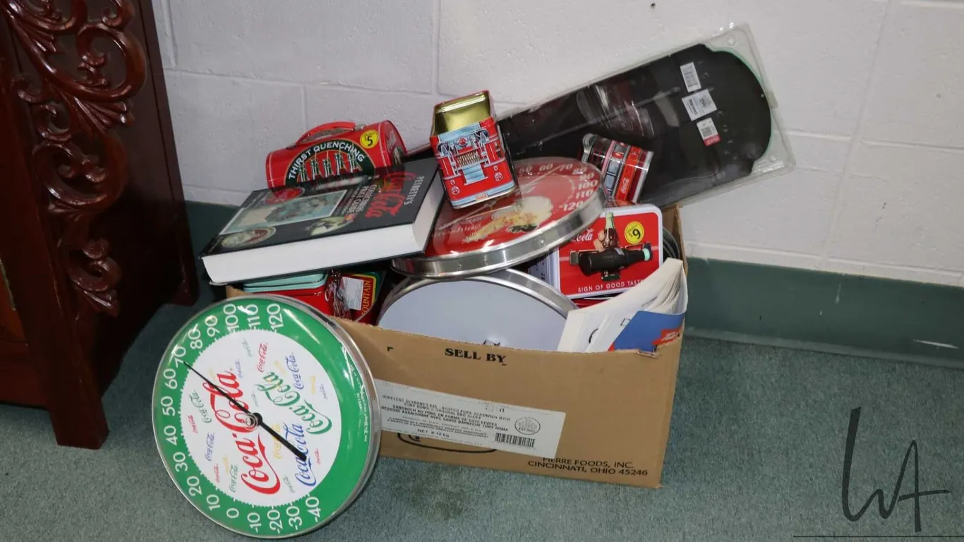 Large selection of Coca-Cola branded items including tin boxes, thermometers, lunch boxes, etc, and