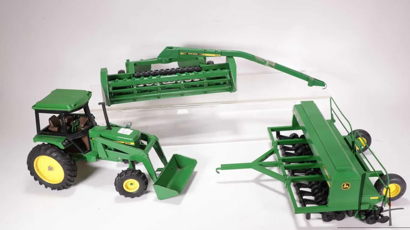 Three Ertl 1:18 scale die cast John Deere toys including 2755 tractor with front end loader, seeder