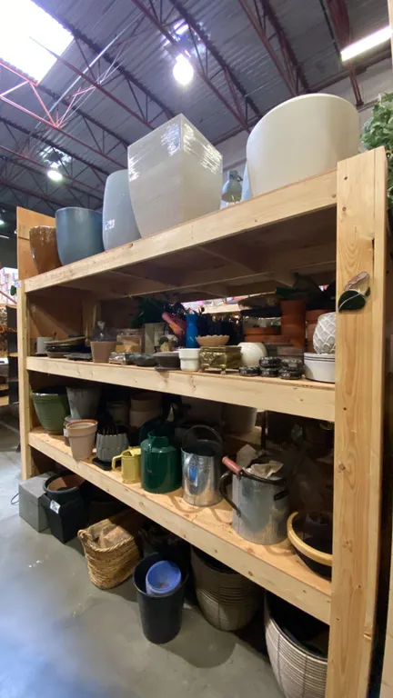 4 SHELVES FULL OF ASSORTED DECORATIVE PIECES - CERAMIC PLANTERS, WATERING CANS, BOXES AND MORE