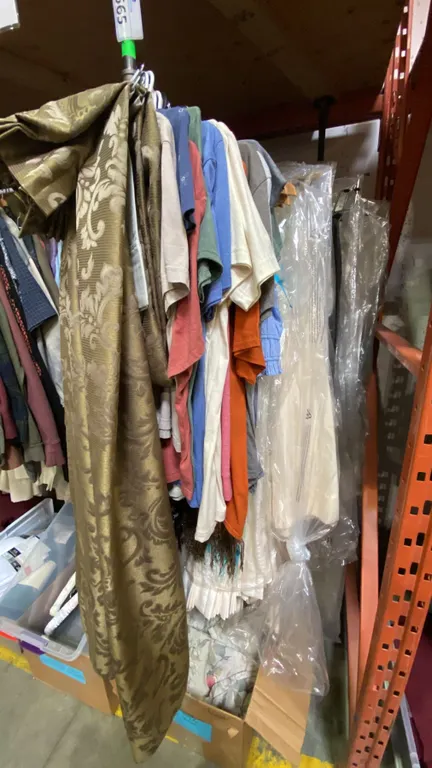 ONE RACK OF ASSORTED CLOTHING AND CURTAINS (MOSTLY CURTAINS) *RACK NOT INCLUDED*
