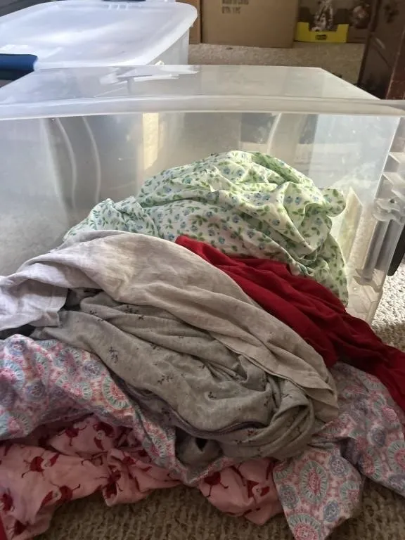 64 quart tote with clothes and bedding
