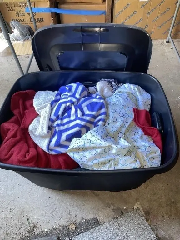 Black tote with clothes, blankets