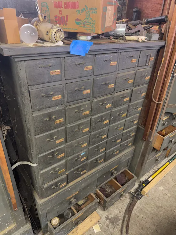 Wooden cabnet with pull out drawers full of hardware