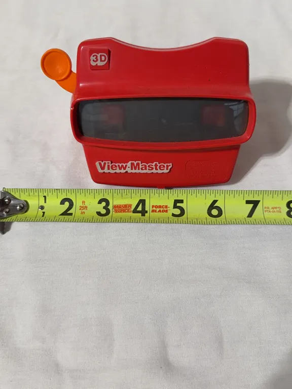 A vintage red plastic View-Master 3D stereoscopic slide viewer from the 70s