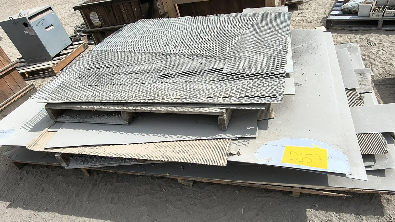 Stack of expanded metal mesh sheets (diamond pattern) in various sizes, plus some solid sheet metal underneath