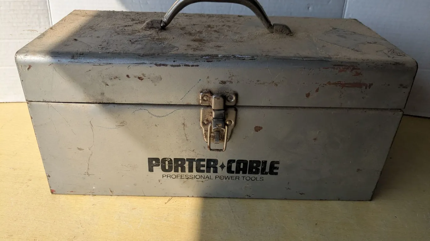 Vintage metal toolbox with assorted tools