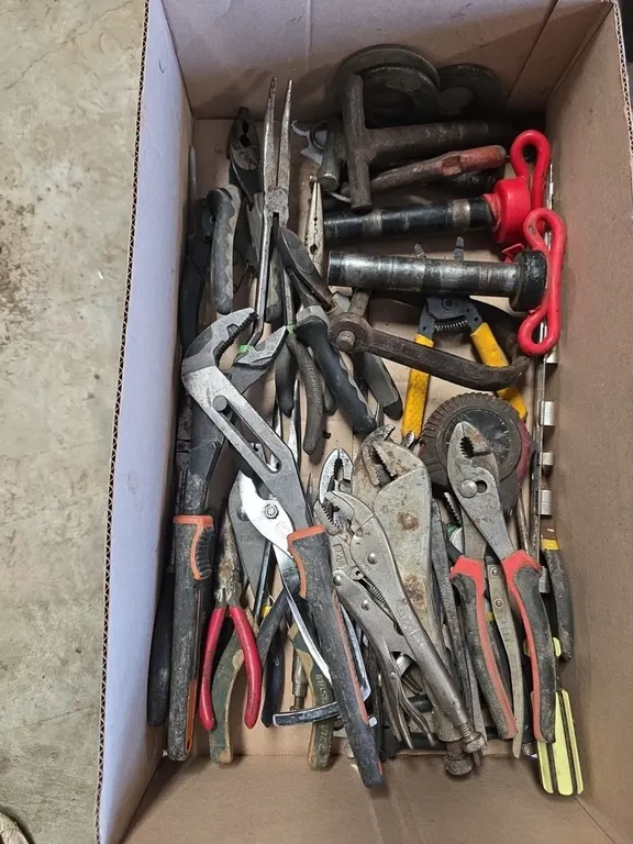 Box of vice grips, hitch pins and pliers