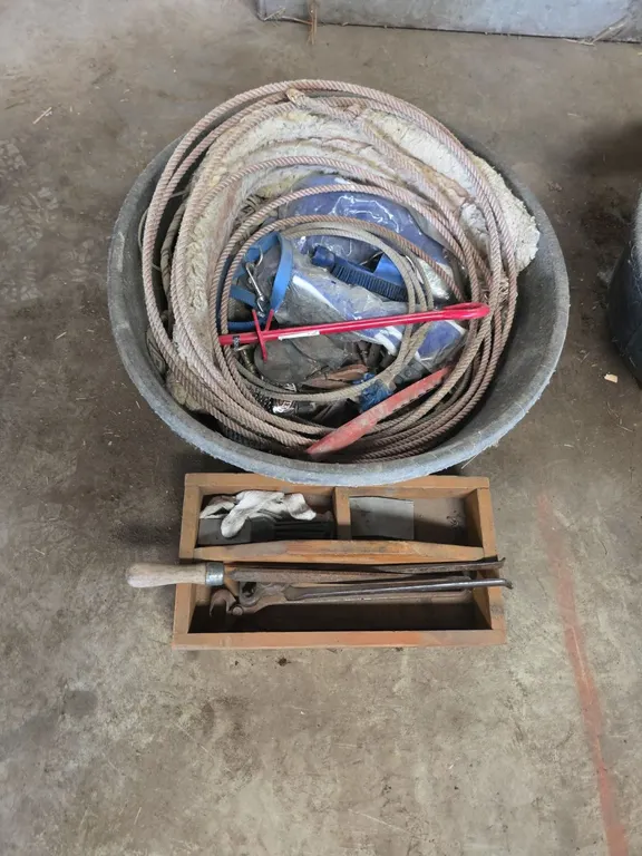 Rubber feed pan full of assorted tack, lariats, horse supplies and container of ferrier equipment