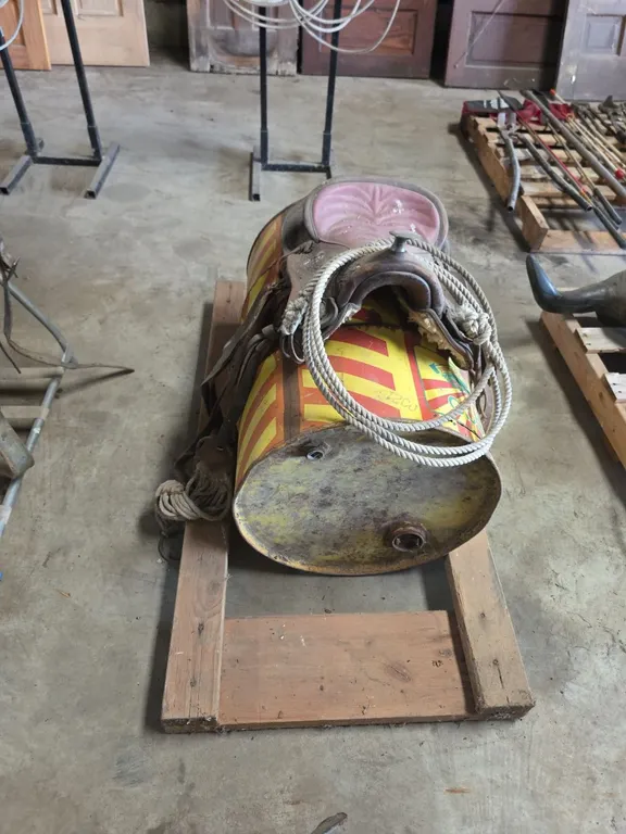 Childrens saddle and lariat on barrel stand
