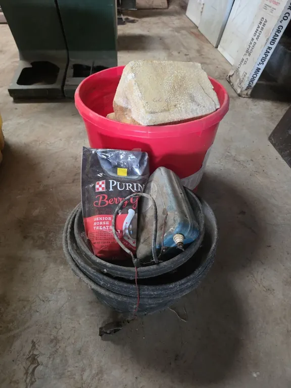 Rubber feed pans, electric fencer, tote of blocks and feed