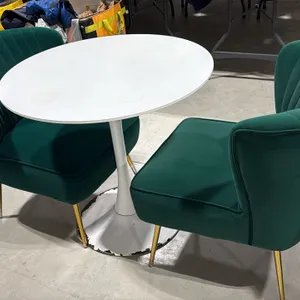 White pedestal table with (2) green upholstered accent chairs. Includes 31.5" round tabletop mounted on a white tulip-style pedestal base. Chairs feat