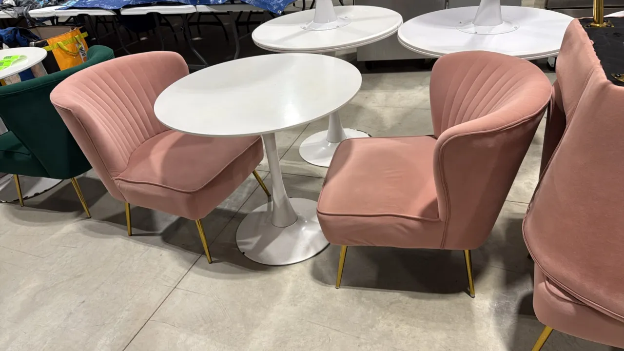 White pedestal table with (2) pink accent chairs. Includes 31.5" round top pedestal table on a flared circular base, and (2) 22"W pink fabric upholste
