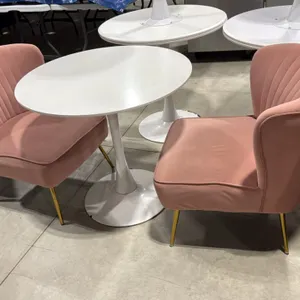White pedestal table with (2) pink accent chairs. Includes 31.5" round top pedestal table on a flared circular base, and (2) 22"W pink fabric upholste