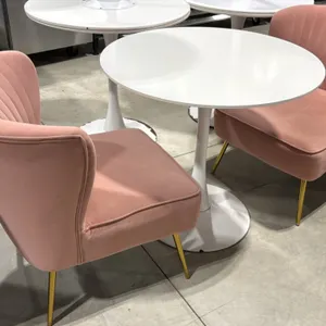 White pedestal table set with (2) pink fabric chairs. Includes a 31.5" round white top table on a tulip-style pedestal base, and (2) 22"W pink upholst