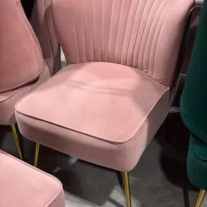 Pink fabric upholstered accent chair. Features a channel-tufted curved backrest and cushioned seat. 22"W. Mounted on gold-tone tapered metal legs.
