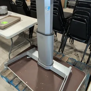 Pneumatic sit-stand desk base. Features a single pneumatic height-adjustable telescoping column with an upper mounting plate and a silver-tone metal b